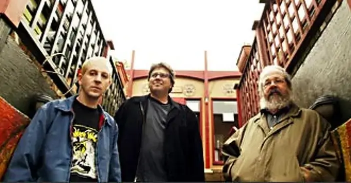 Three of the five co-founders of the Grand Illusion nonprofit standing on the fron entry steps